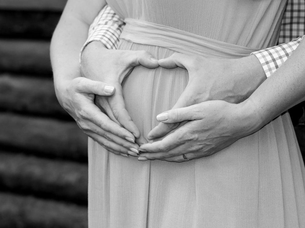 Partner behind with hands on bump